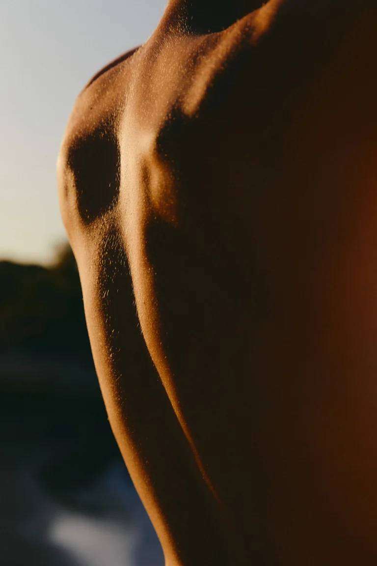 Sunlight and shadow across a bare shoulder