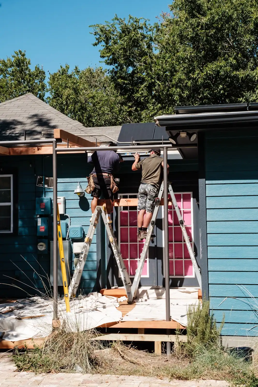 Crew members working on the timber structure of a screened porch